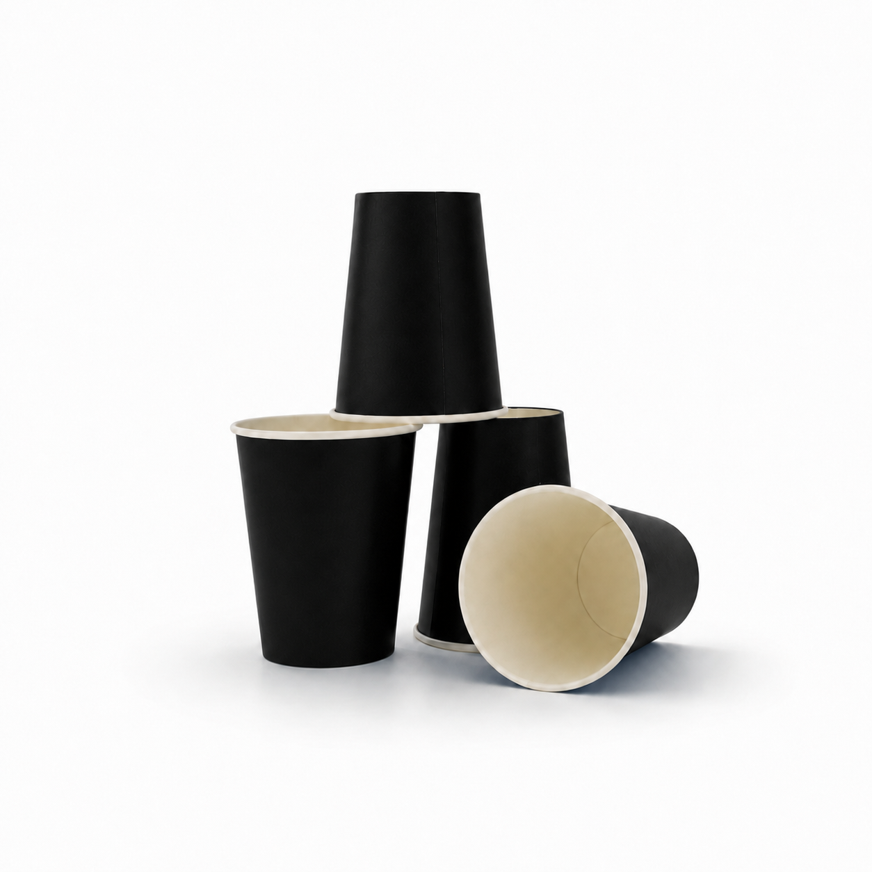 Three black paper cups with cream-colored interiors, arranged in a stacked and tipped-over display on a clean white background.