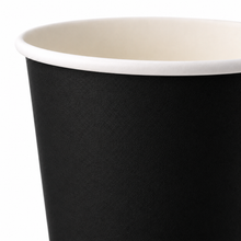 A close-up of a black paper cup with a white inner lining and white rim, shown against a plain white background.