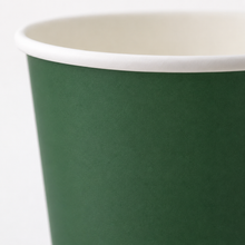 A close-up of a paper cup with a dark green exterior and a white interior rim, shown against a plain white background.