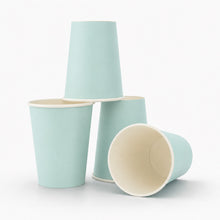 Four Mint paper cups arranged on a clean white background, with three standing and one lying on its side to show the cream-colored interior.