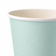 A close-up of a paper cup with a light mint green exterior and a cream-colored interior, shown against a plain white background.