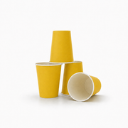 Three yellow paper cups arranged on a white background, with one standing upright, one lying on its side showing the white interior, and one standing behind the others.